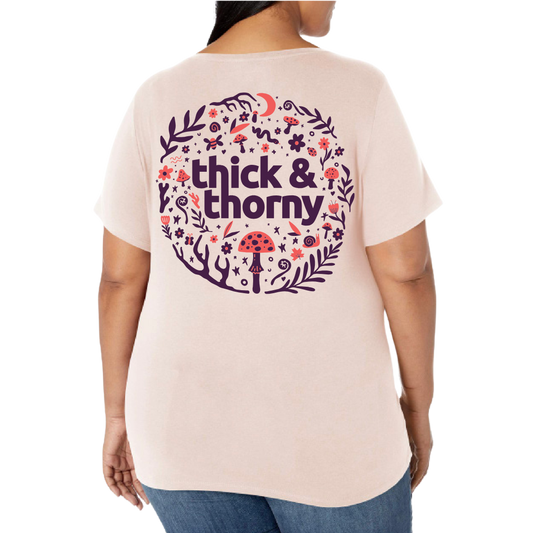 Person wearing a light pink t-shirt with 'thick & thorny' design on the back