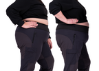 two people wearing black top and slippy rock thicket pants, one booty fit, one belly fit.
