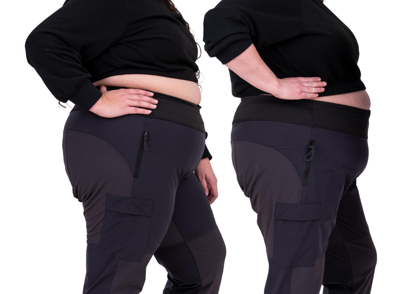 two people wearing black top and slippy rock thicket pants, one booty fit, one belly fit.