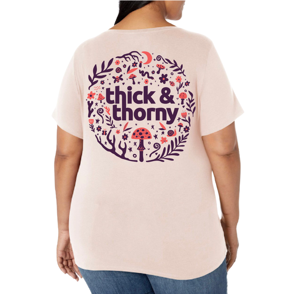 Person wearing a light pink t-shirt with 'thick & thorny' design on the back