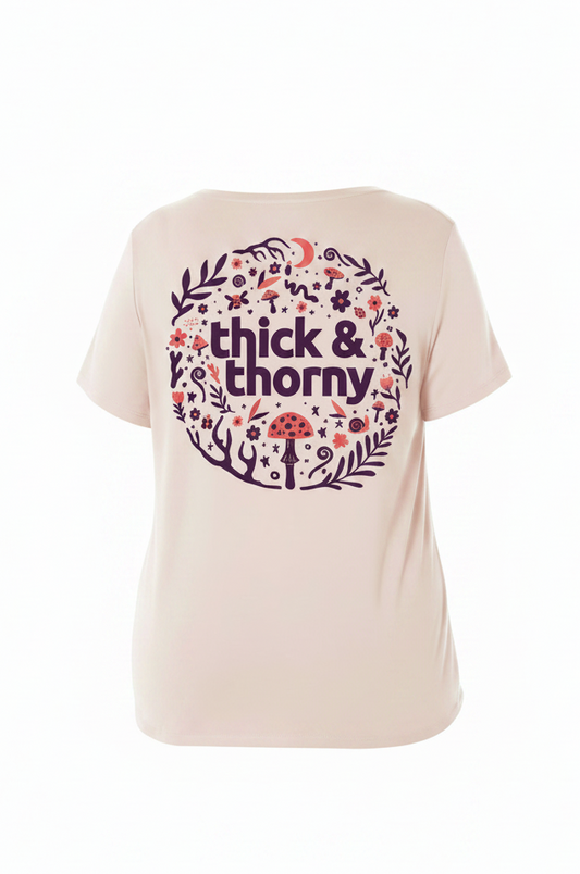 Beige t-shirt with floral design and 'thick & thorny' text on a white background